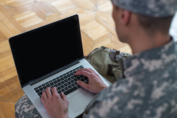 Soldier holding laptop. Military education concept