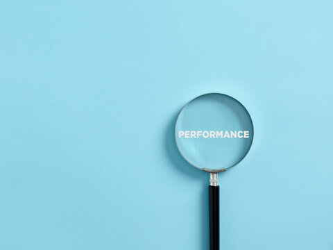 Magnifier focuses on the word performance. Analyzing or reviewing business job or employee performance
