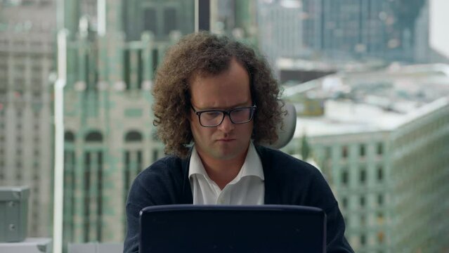 SLOW ZOOM OUT Portrait of scared nerdy office worker closing laptop after doing something wrong online