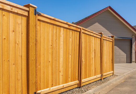 Nice new wooden fence around house. Wooden brown fence. Street photo, nobody