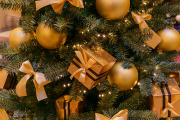 Christmas and New Year holidays background. Christmas tree decorated with golden balls and gift boxes. Celebration concept