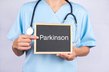 Ärztin zeigt auf eine Tafel auf der Parkinson steht