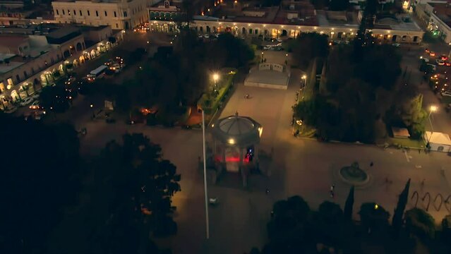 Night View Of Municipal Ciudad Guzman Garden With Illuminated Gazebo In Jalisco, Mexico. aerial drone tilt-up