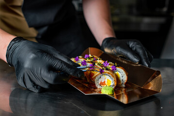 chef decorating sushi rolls hand