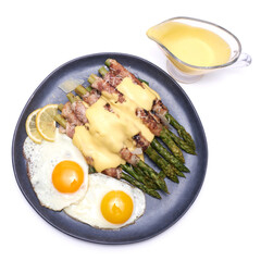 Healthy food - Asparagus wrapped with bacon and spices on a plate isolated on white background