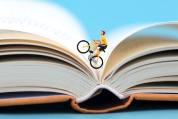 Miniature creative cycling on open book