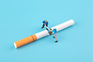 Miniature scene worker sawing off cigarette