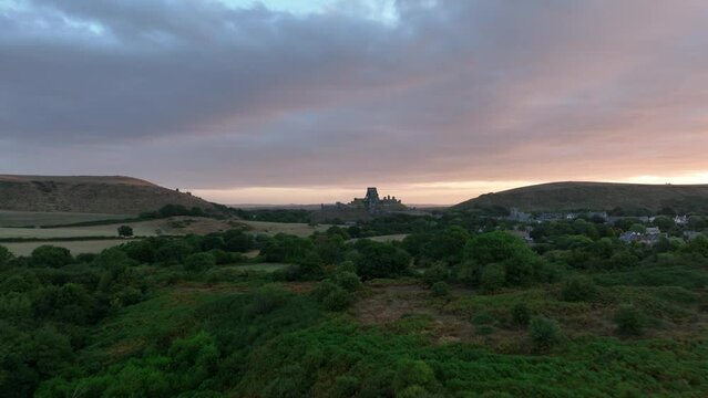 Corfe Castle at sunrise, aerial view over Corfe common towards the castle.