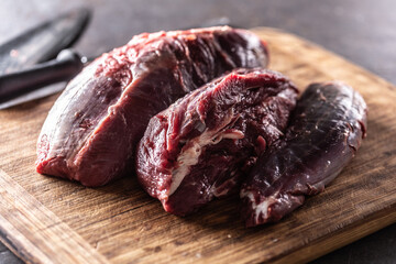 Pieces of raw beef shank placed on a wooden cutting board