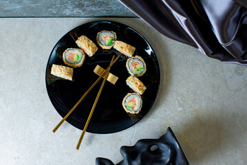 Sushi rolls on a black plate