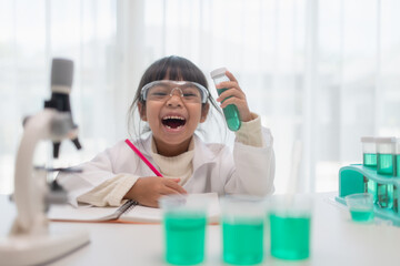 Naklejka premium education, science, chemistry, and children concept - kids or students with test tube making experiment at school laboratory