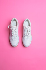 Upper View of Pair of New White Sneakers Over Pink Seamless Background.