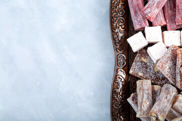 Turkish Sweets with different flavors. Turkish Delight on metal tray, close-up. Gelatin dessert. Grey background, copy space