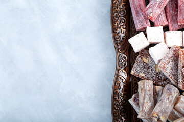 Turkish Sweets with different flavors. Turkish Delight on metal tray, close-up. Gelatin dessert....