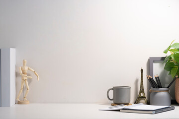 Minimal workplace with empty picture frame, book, coffee cup and pencil holder on white table. Copy space for your text.