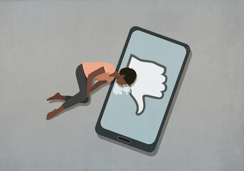 Woman crying on smart phone screen with social media dislike button
