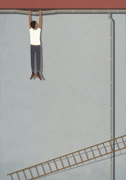 Man hanging from bending pipe above fallen ladder
