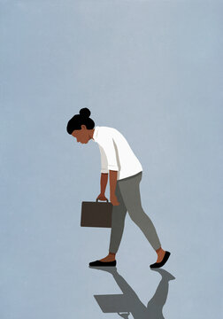 Slumped, tired businesswoman walking with briefcase
