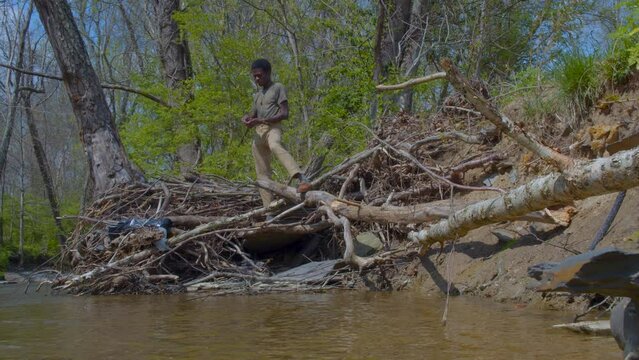 Adult black man leisurely playing ricochet near creek in Kentucky during spring