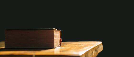 Bible of christian put on wooden table with light in morning. Close up concept.