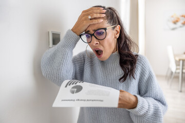 Woman is shocked from the rising energy costs and the bill she received for heat and electricity...