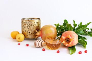 Rosh hashanah (jewish New Year holiday) concept. Pomegranate and honey traditional symbols over white background