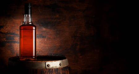Bottle of whiskey on the old barrel