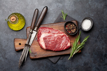Raw ribeye steak on cutting board