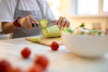 Obraz na płótnie Canvas Close up of a woman cutting vegetables on the cutting board
