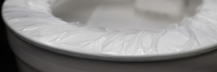 disposable cover pad on the rim of the toilet seat. wc hygiene system in public washroom. toilet...