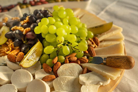 Close up cheese board with grapes and almonds
