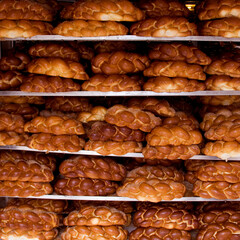 Loaves of freshly baked challah egg bread rest on display racks outside a bakery on a Jerusalem street on the eve of the Jewish sabbath.