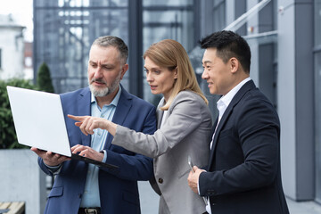 Successful business team, three colleagues businessman and businesswoman outside office building...