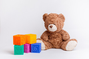 teddy bear with cubes and a pyramid on a white background