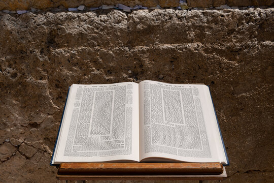 A large volume of the Jewish Talmud open to the text from the tractate Ketubot rests on a prayer stand in front of the Western Wall in Jerusalem.