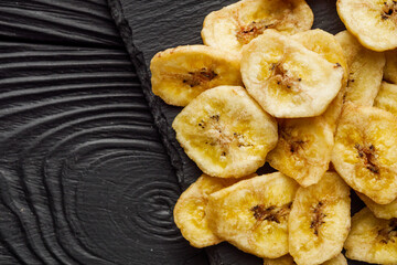 delicious dried banana on a black wooden rustic background