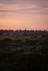 Sunrise over village with fog in denmark