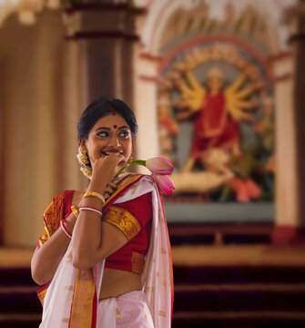 Bengali woman with lotus at puja pandal on the occasion of Durga Puja
