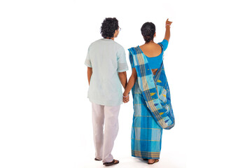 Back view of Bengali couple standing against white background