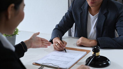 Shot of lawyer or attorney explaining terms, condition on legal document to client before signing on contract at law firm