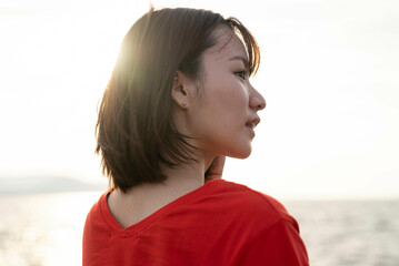 夕暮れの海にいる女性