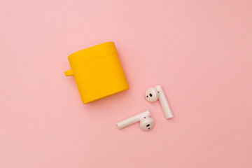 Wireless headphones on a pink background, subject shot