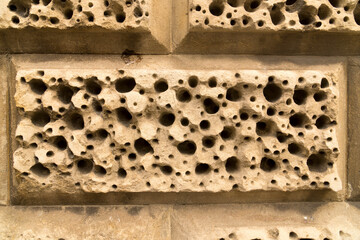 Closeup sandstone bricks wall decoration holes background