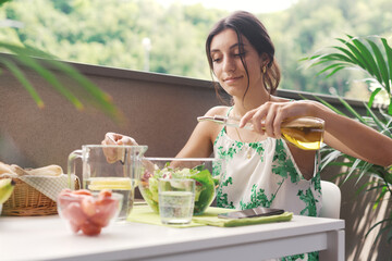 Woman pouring oil on her salad