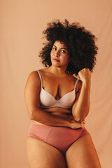 Confident woman with an Afro hairstyle wearing underwear in a studio