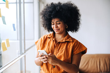 Black businesswoman using a smartphone in a creative office