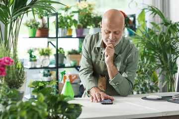 Professional florist taking orders on his smartphone