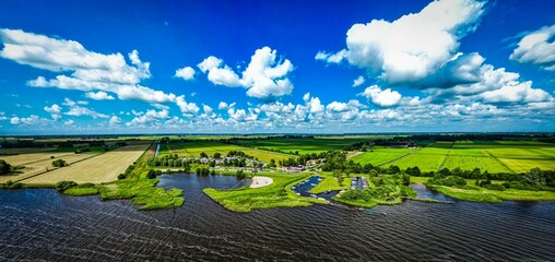 Panoramic, aerial shot of a wonderful lake landscape with green fields and a harbor