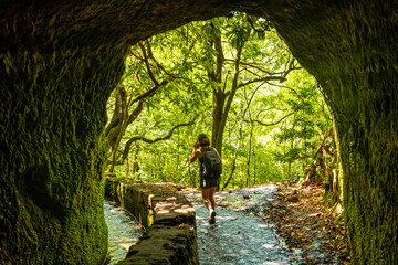 A young woman trekking in the cave at Levada do Caldeirao Verde, Queimadas, Madeira