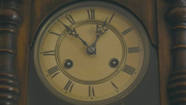 Beautiful and antique hanging pendulum clock, detail of Roman numerals and hands